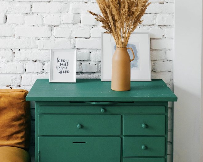 Green drawers with framed images on top